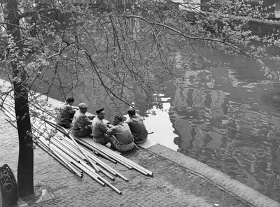 361191 Afbeelding van enkele pauzerende werklieden op de rand van de werf langs de Oudegracht te Utrecht.